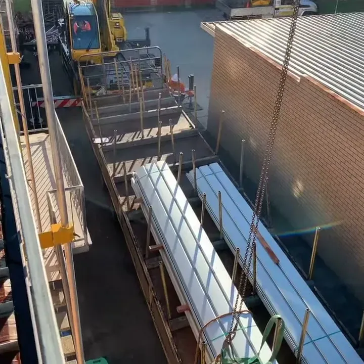 Bundles of new clip-lock roof sheets landed by crane during a Ballina re-roof